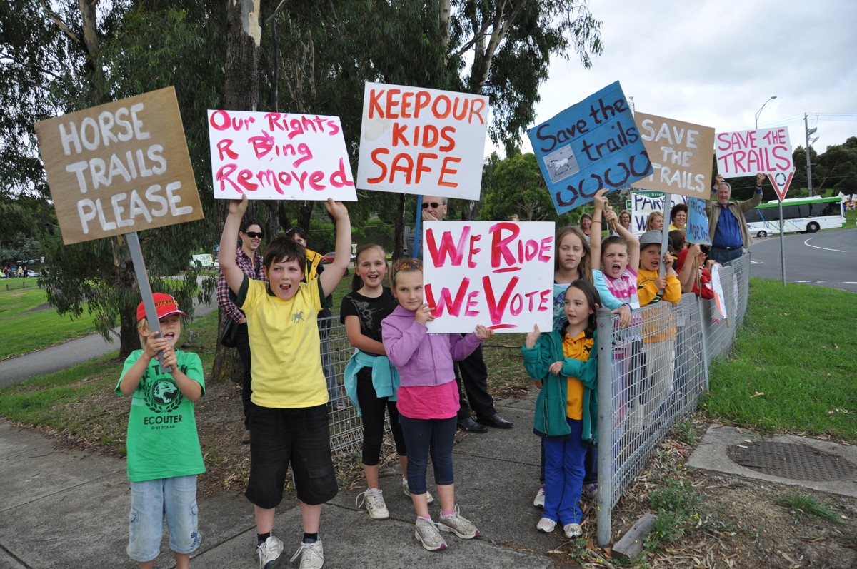 Children holding Save The Trails placards at the rally