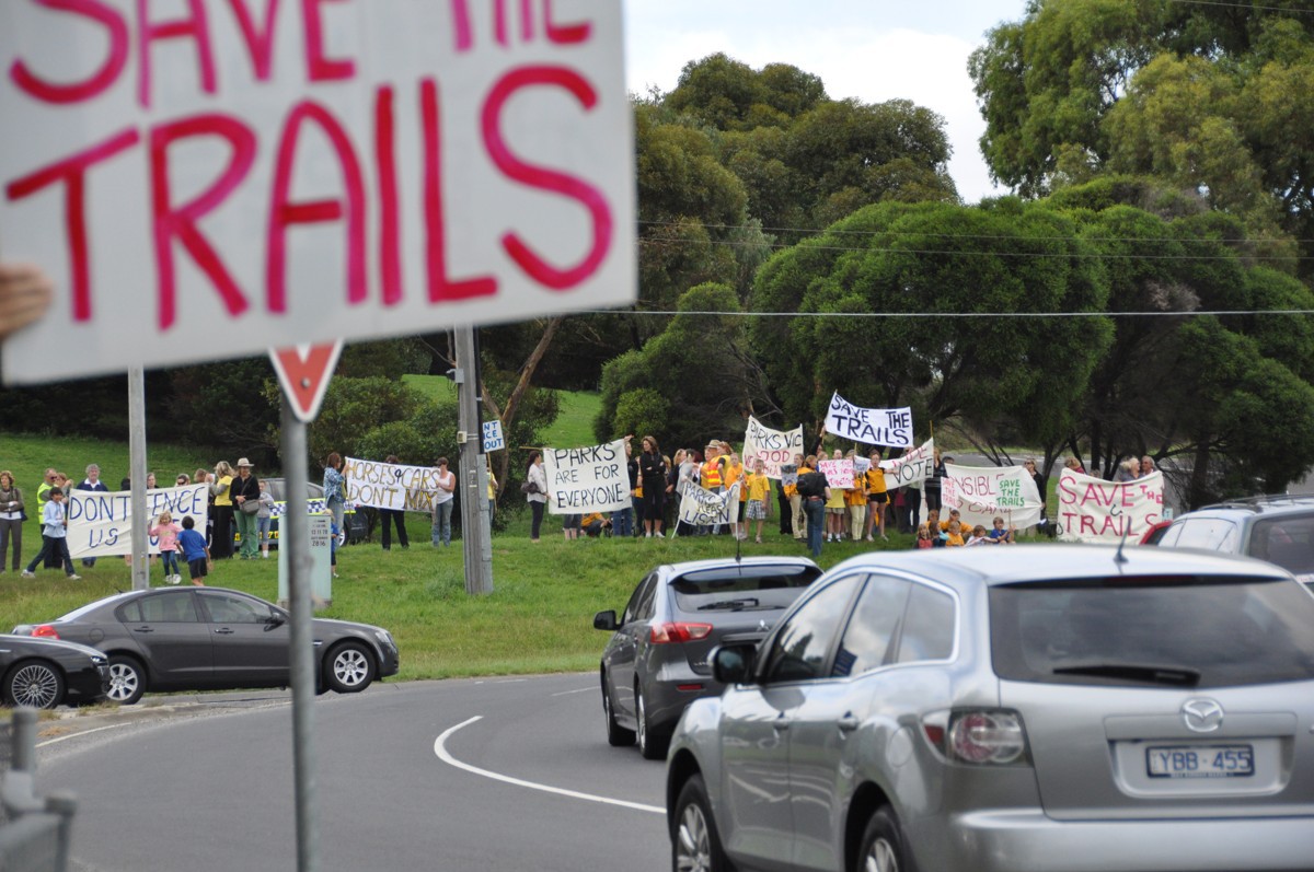 Riders and families marching with Save The Trails placards