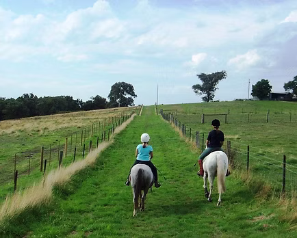 Two young riders on a farm track